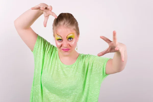 Beautiful woman with green makeup and clothes that casts a spell — Stock Photo, Image