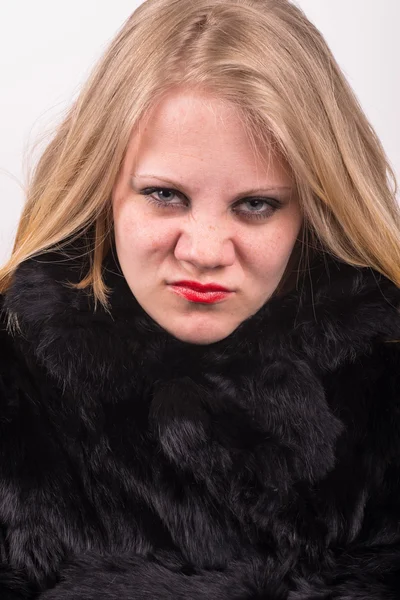 Cocky angry young cute young woman in fur jacket Stock Photo