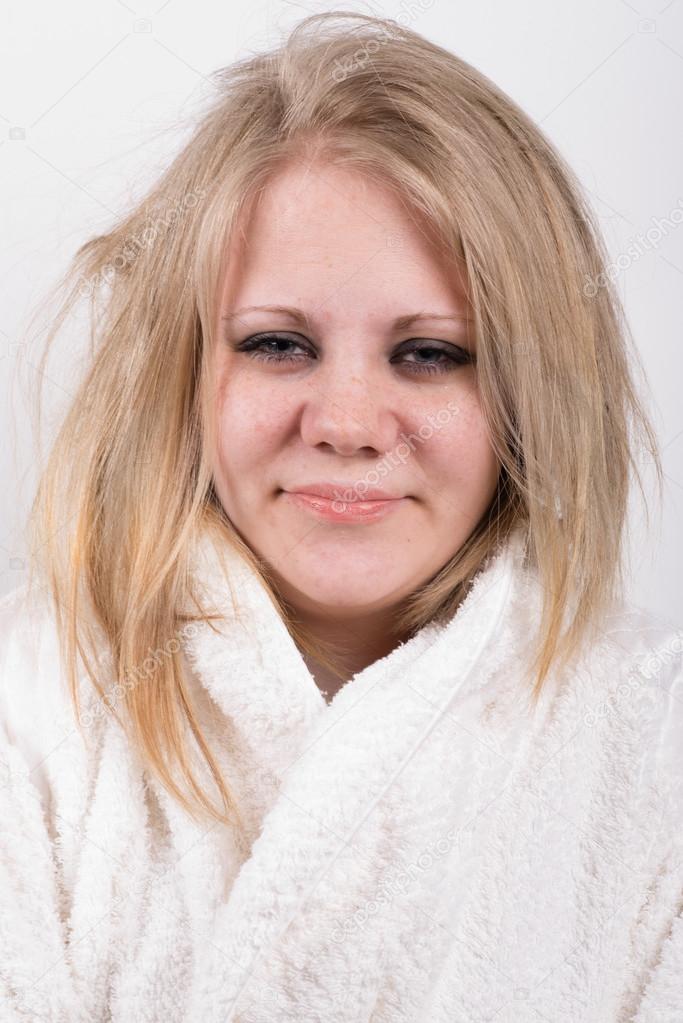 tired young cute woman in bathrobe