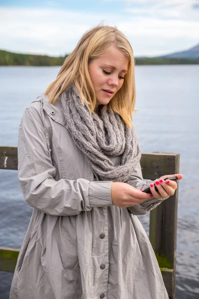 Fiatal nő olvasó lány smartphone Stock Kép