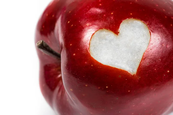 Primo piano di una deliziosa mela rossa con un cuore ritagliato — Foto Stock