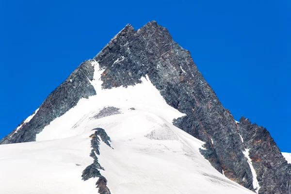 Pináculo con nieve debajo y un cielo azul claro arriba — Foto de Stock