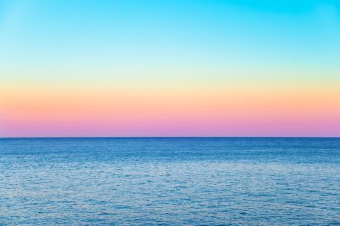 pastel gökyüzü altında sakin bir deniz