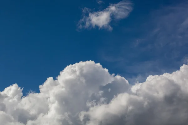 Wolken in verschillende vormen op een diep blauwe hemel. — Stockfoto