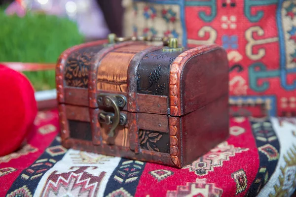 Una pequeña caja de madera en la alfombra. Una pequeña caja de madera . — Foto de Stock