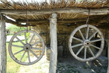 At arabasının tekerleği. Tahta, eski at arabası. At arabasının tekerleği asıldı. .