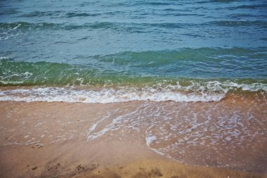 Hazar Denizi suyu beyaz kumsal üzerinde. Temiz ve rahatlatıcı deniz dalgaları sahile vuruyor. Tropik cennetin mercan plajı. Plaj düğünü ya da balayı için deniz manzarası. Egzotik deniz kenarı afişi