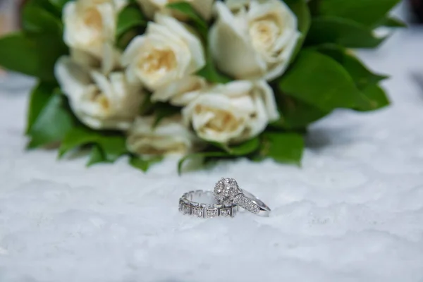 时尚的白色婚礼花环在婚礼花束前 在一束美丽的玫瑰的背景下 结婚的订婚戒指 — 图库照片