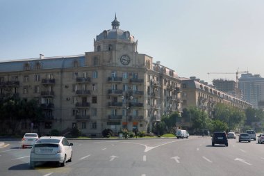 Azerbaycan Bakü. - 14. 05: 2021. Heydar Aliyev Bulvarı. Asfalt yolun kenarındaki beş katlı modern evler. Dört şeritli otoyol .
