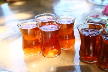 Türk ya da Azerbaycan çayı armut şeklinde bardaklarda, etnik ulusal masa örtüsü üzerinde fincan tabakları, Ramazan veya Novruz için geleneksel doğu sıcak siyah çayı. Kapsülün içinde bir bardak armut çayı .