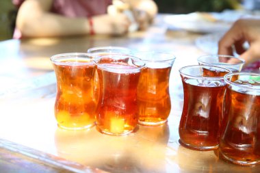 Armudu bardağında çay. Tepside Armudu çayı. Türk ya da Azerbaycan çayı armut şeklinde bardaklarda, etnik ulusal masa örtüsü üzerinde fincan tabakları, Ramazan veya Novruz için geleneksel doğu sıcak siyah çayı .