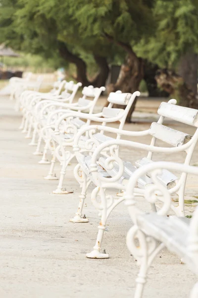 Белые скамейки в парке — стоковое фото