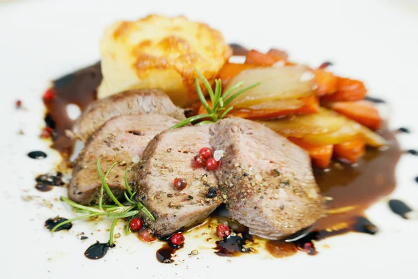 Steak d'agneau tranché avec gratin de pommes de terre et différents légumes — Photo