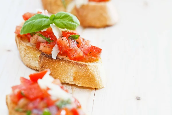 Verse zelfgemaakte krokant Italiaanse antipasto genaamd bruschetta gegarneerd Stockfoto