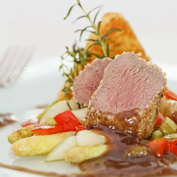 Roasted saddle of lamb on asparagus ragout and herbs — Stock Photo, Image