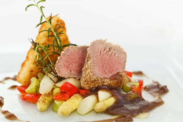 Roasted saddle of lamb on asparagus ragout and herbs — Stock Photo, Image