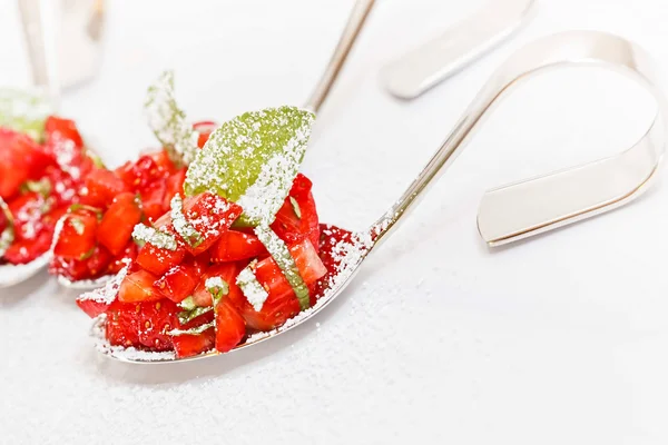 Erdbeersalat gemischt mit Zucker und Minze, serviert auf einem Löffel — Stockfoto