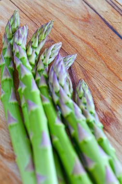 Demet taze yeşil kuşkonmaz spears bir rustik ahşap üzerinde