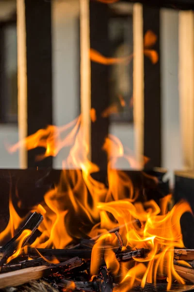 Gros plan, feu rugissant avec des flammes floues provenant de billes de bois dans un foyer de pierre . — Photo
