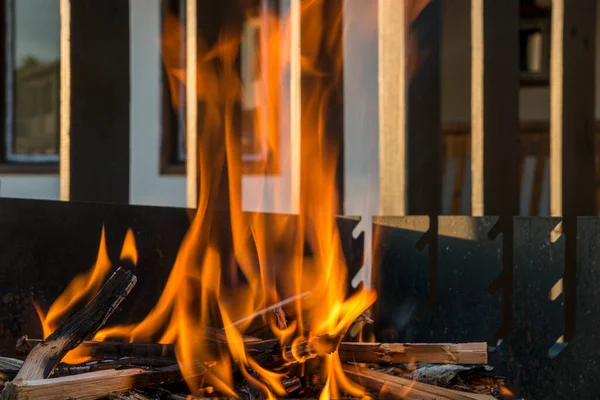 Gros plan, feu rugissant avec des flammes floues provenant de billes de bois dans un foyer de pierre . — Photo