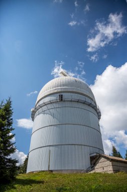 Bulgar dağlarında mavi gökyüzüne karşı teleskoplu küçük astronomik gözlemevi.