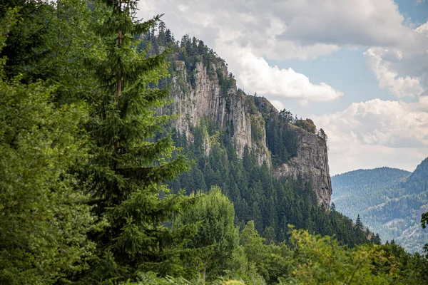 Parlak mavi gökyüzü ve kalın kabarık bulutlar, günbatımı manzarasında dar patikalı yeşil dağ sırtlarının üzerinde süzülüyor..
