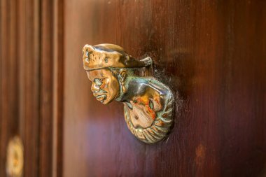 Old wooden doors with rings and old-fashioned vintage steel knocker handle close up.