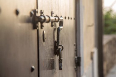 Old wooden doors with rings and old-fashioned vintage steel knocker handle close up.