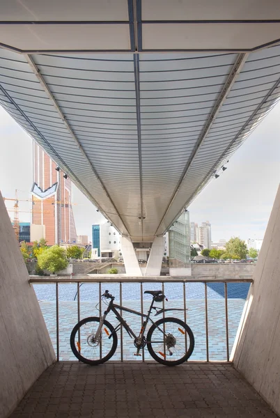 Bicicleta estacionada bajo los pies del puente — Foto de Stock