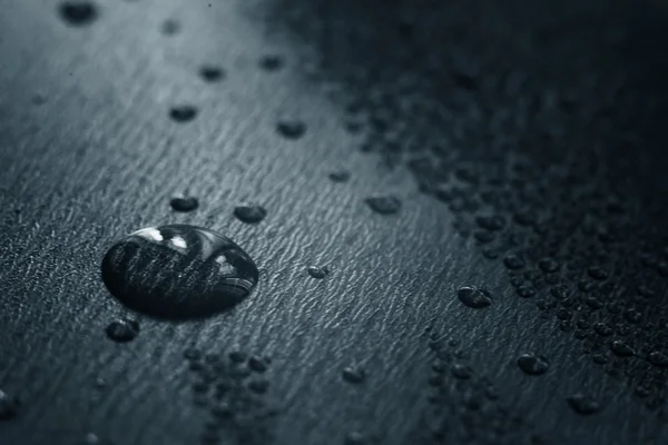 Drops on black surface — Stock Photo, Image