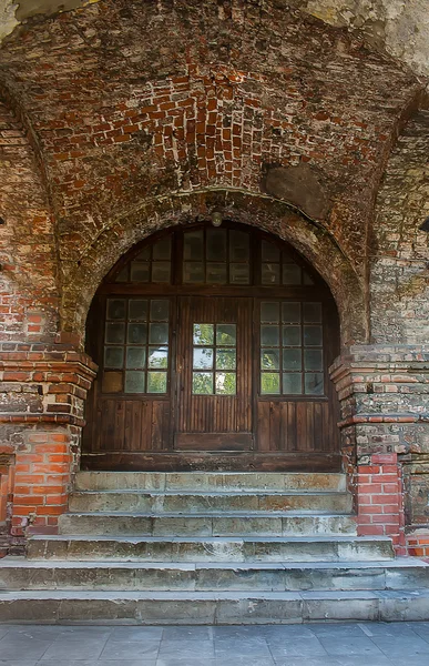 Fachada del antiguo edificio de ladrillo con un arco — Foto de Stock