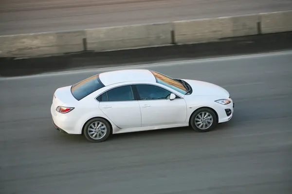 Coche blanco conduciendo en la calle de la ciudad — Foto de Stock