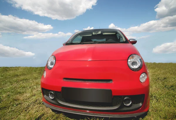 Červené auto na zelené trávě — Stock fotografie