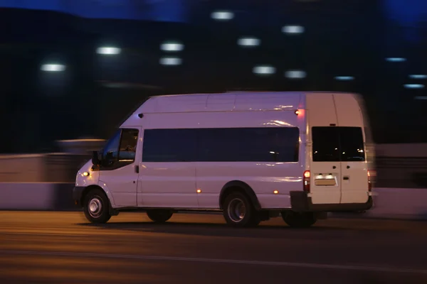 Minibuss flyttar ner på gatan på natten — Stockfoto