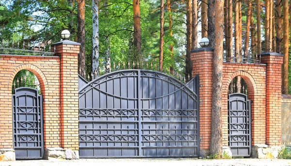 Bakstenen muur met metalen hek — Stockfoto