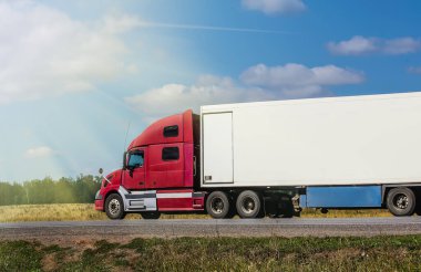 Bir yaz gününde kırsal bir yolda büyük bir yarı karavan hareket eder..