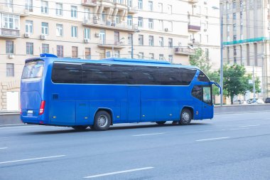 Turist otobüsü şehir caddesinde gidiyor.