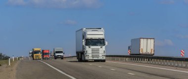 Kamyonlar karşı istikamette bir banliyö otoyolu boyunca ilerliyor.