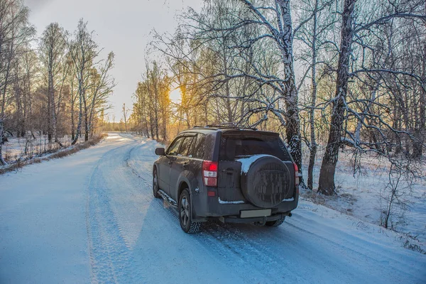 Araba Gün Batımında Ormanda Bir Kış Yolunda Ilerliyor — Stok fotoğraf
