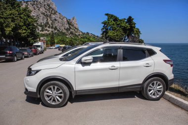 Arabalar deniz dağı kıyısındaki otoparkta.