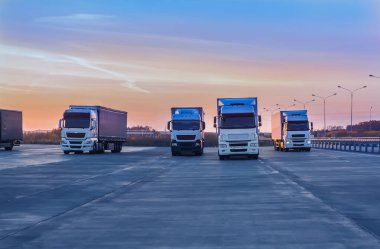 Şafak vakti banliyö otobanındaki bir otoparkta kamyonlar