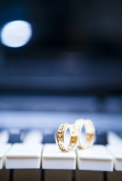 Gouden trouwringen op een piano Stockfoto