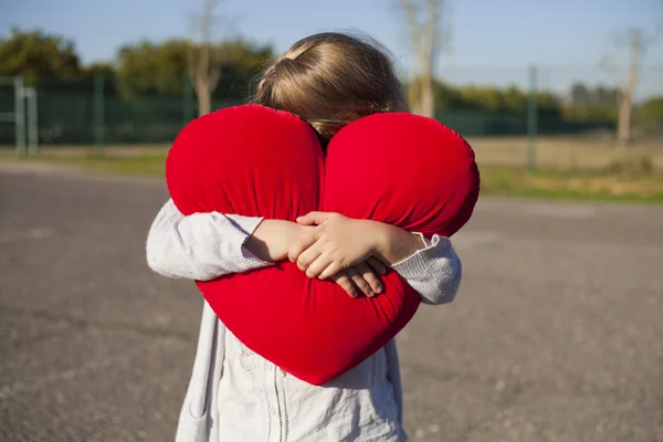 Mladá dívka drží tvar srdce — Stock fotografie