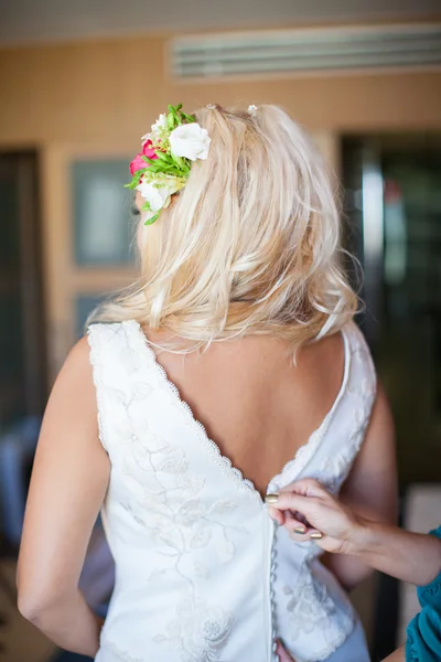 Bridesmaid tying bow on wedding dress — Stock Photo, Image