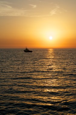 Denizin üzerinde gün batımı.