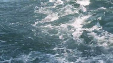 Nehirde akan bir su, köpükle dalgalanır.