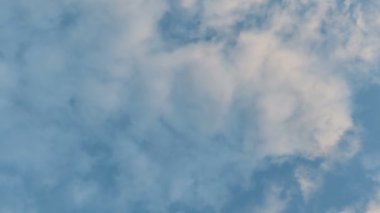 Mavi gökyüzüne doğru hareket eden beyaz bulutlar, hızlandırılmış video