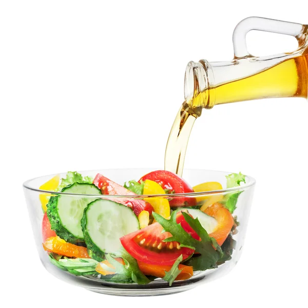 白いれたらにボトルから注ぐ油と野菜のサラダ — ストック写真