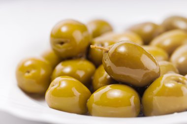 Beyaz bir tabak içinde yeşil zeytin