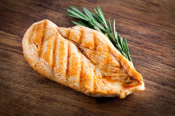 Grilled organic chicken with rosemary on wood — Stock Photo, Image